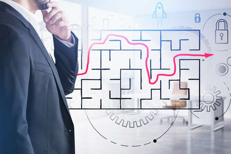 Businessman wearing formal suit is standing and touching his chin with a hand. Sketch with labyrinth with red line, padlock, cogwheel, rocket start up. Office in background. Concept of making decisionの写真素材
