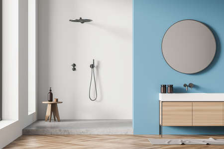 Shower room interior with white and gray shower cabin, stool, on trend round mirror, vanity and blue wall. Wood tile floor. A concept of modern house design. 3d renderingの写真素材