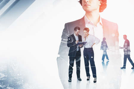 Group of business people work together to achieve the best results for their company. Curly serious businessman in the foreground. City skyscraper downtown in the background. Concept of teamworkの写真素材