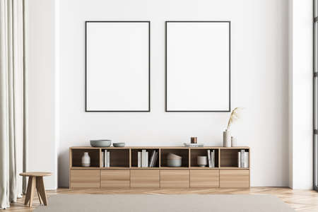 Two posters on the wall of the minimalist beige living room. Interior with sideboard, stool,...