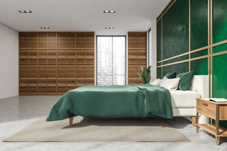 Elegant malachite green wall with panel cover, designed for the bedroom interior, having bed, cabinets, bedside table, beige rug and concrete floor. A concept of modern apartment design. 3d renderingの写真素材