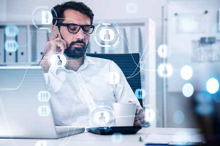 Handsome beard businessman in glasses wearing formal shirt and talking smartphone to check social...