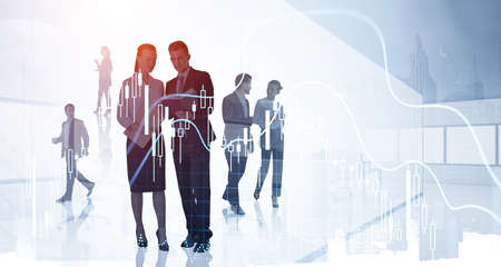 Businessman wearing formal suit and businesswoman in white shirt discussing new working strategy. Office workplace in background. Forex candlestick. Concept of teamwork, cooperation and communicationの写真素材