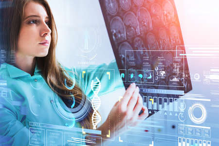 Female doctor wearing teal suit is looking at radiograph of skull. Digital interface with icons of dna, lungs, heart, brain, stomach, pills in foreground. Concept of heath care and diagnosticsの写真素材