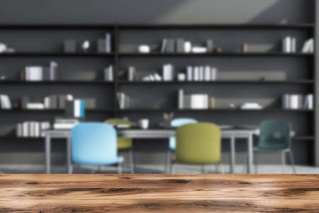 Table for product display with creative gray staff meeting room interior, having a collaboration table with blue and green chairs and a shelving on the background. Ad design concept. 3d renderingの写真素材