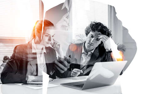 Young businessman and smiling attractive businesswoman work together at office workplace and make a...