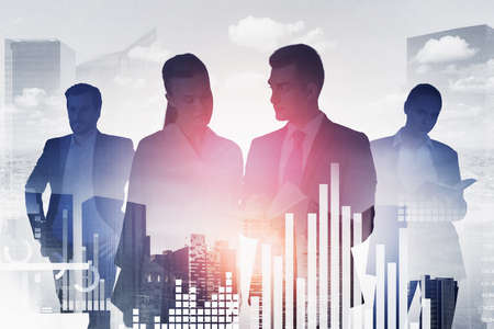 Group of business people work together talking and discussing. Singapore city skyscraper in the background. Bar and pie diagrams in the foreground. Concept of relationship between colleaguesの写真素材