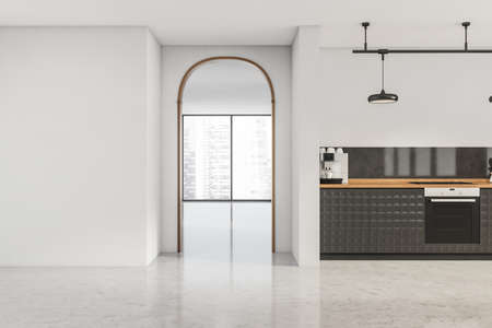 Archway to the next panoramic area and white kitchen interior with textured black cabinets and a...