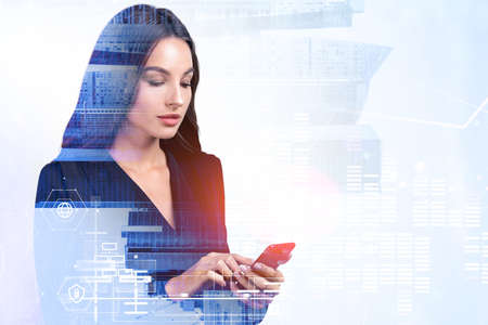 Young attractive businesswoman wearing formal suit is holding smartphone and typing message....
