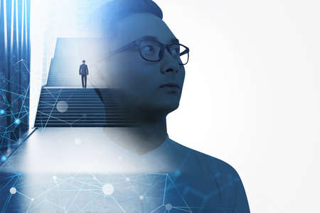 Side view of young Asian businessman in glasses looking at blank wall with double exposure of stairs with another man. Career ladder concept. Connected white dots as information flowの写真素材
