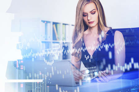 Businesswoman wearing black dress is taking notes in front of laptop. Digital interface with rising graph in foreground. Singapore city in background. Concept of futuristic technologies in businessの写真素材