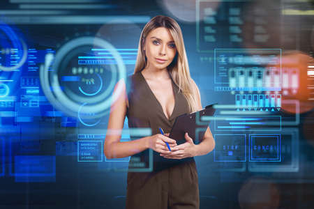 Young attractive businesswoman wearing formal jumpsuit is holding clipboard. Digital interface with...