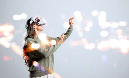 Businesswoman in green sweater is wearing vr helmet. Digital interface with geometrical figures and...