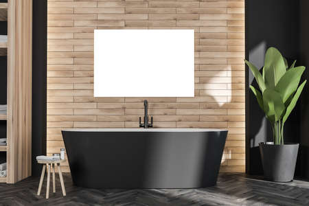 Horizontal poster on wood-look wall in modern bathroom interior with oval black bathtub and on trend...