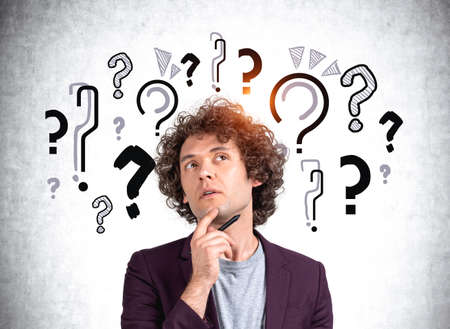 Office man portrait with hand to chin thinking, looking for answers. Background of doodle question...