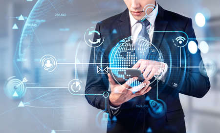 Businessman wearing formal suit is typing message on tablet. Office workplace in the background....