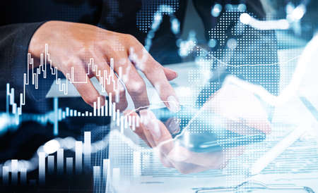 Woman hands using smartphone, analysing stock market changes. Double exposure hologram of blue changing lines, desk with documents. Concept of online trading and technologyの写真素材