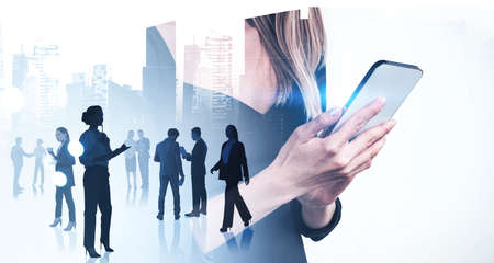 Businesswoman and businessman wearing formal suits work together typing on smartphones. Singapore...