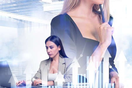 Two office people, team with computer and pen to chin pensive look, stock market changes hologram. Rising arrows and bar chart. Concept of partnershipの写真素材