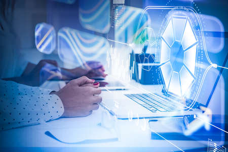 Two businesswomen wearing white shirt and is sitting in front of laptop. Digital hologram Interface...