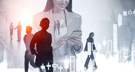 Businesswoman with phone smiling, double exposure with office skyscrapers in New York. Office people communicate and handshake, rising candlesticks. Concept of online tradingの写真素材