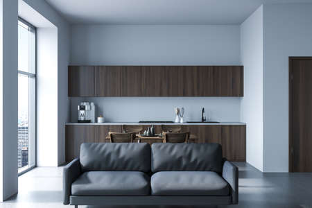 Minimalist cooking interior with black couch on concrete floor, chairs and dining table with dishes....