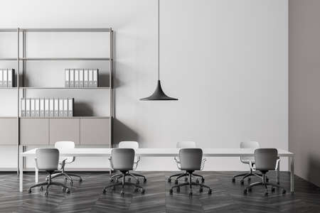 Light gray meeting room interior with pendant lamp over table with eight rolling chairs, dark...