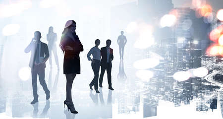 Silhouettes of diverse walking positive business people looking for solutions in abstract office space with night financial downtown skyscrapers skyline view. Double exposureの写真素材