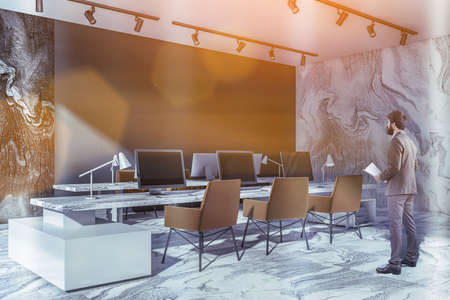 Tiled office room interior with armchairs and pc in row, office man with papers in hand. Coworking...