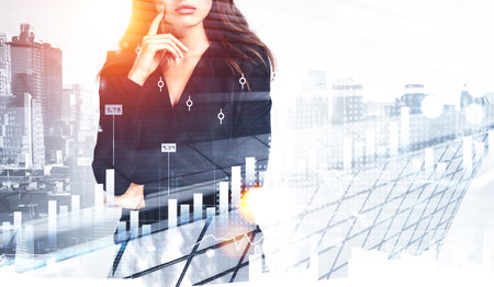 Office woman with thoughtful look, finger to cheek, New York buildings and stock market graph changes with candlesticks and bar chart, double exposure. Concept of investmentの写真素材