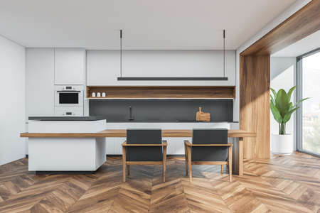 Minimalist white and gray kitchenroom interior with linear light over breakfast bar table, two...