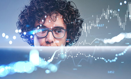Office manager concentrated look, working with computer, stock market bar chart and rising...