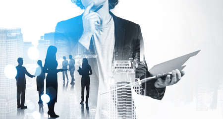 Office man in casual suit with business document, thinking, double exposure of business skyscrapers in New York and people teamwork. Concept of contract and international companyの写真素材