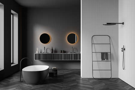 Gray bathing room interior with tub and two sinks with round mirrors, douche and rail ladder, black parquet floor and window. 3D renderingの写真素材