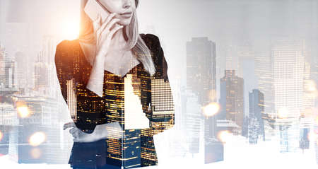 Office woman in black dress, talking on the phone. Double exposure with New York city view at night....