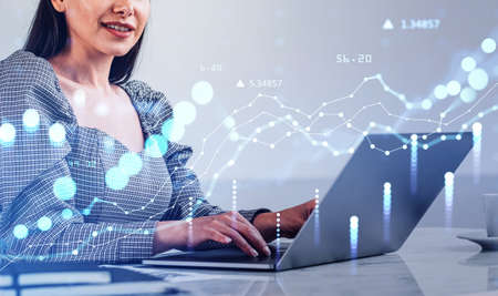 Woman smiling and typing in computer keyboard, double exposure with glowing blue chart with rising...