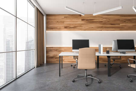Close up view on bright office room interior with panoramic window, four desktops, comfortable armchairs, desks and concrete floor. Perfect place for working process. Minimalist design. 3d renderingの写真素材