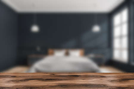 Wooden desk on foreground, blue and wooden bedroom interior, front view, parquet floor near window. Nightstands with lamps. Mockup for display of product, 3D renderingの写真素材