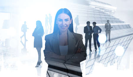 Businesswoman smiling, confident look. Silhouettes of diverse business people working together, double exposure of city skyscrapers. Concept of boss and staffの写真素材