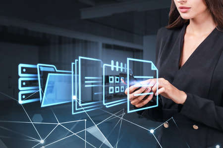 Businesswoman working with smartphone, digital hud screen with office document icons. Storage of personal data information, online database. Concept of cloud serviceの写真素材