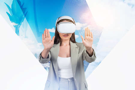 Businesswoman in formal wear is wearing vr helmet. Digital interface with New York city skyscraper with plant in the background. Concept of virtual realityの写真素材