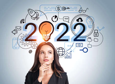 Office woman thinking with hand to chin, lightbulb with 2022 and different icons on blue wall....
