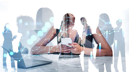 Office people silhouettes, woman typing in smartphone, laptop and contract on the table. Stock market graph changes, double exposure, teamwork. Concept of network and communicationの写真素材