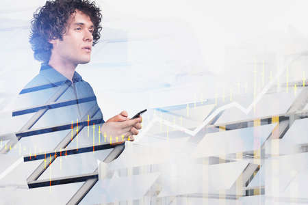 Office man thoughtful look, holding smartphone in hands. Stock market candlesticks with rising...