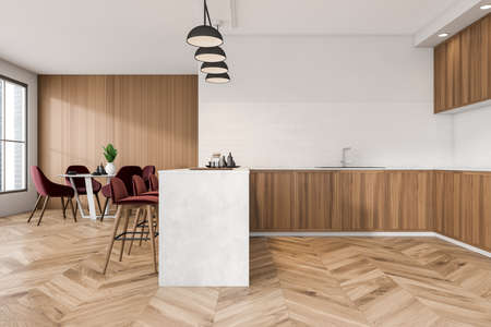 Modern cooking interior with sink and deck with dishes, red chairs and table on parquet floor,...