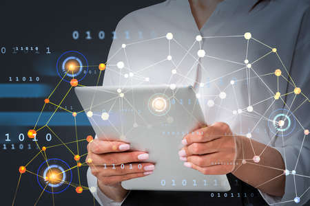 Businesswoman wearing formal shirt works on tablet device typing message. Digital interface with...