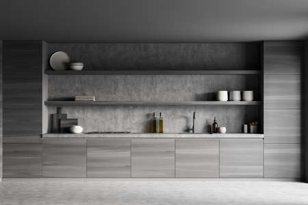 Dark kitchen interior with sink, deck with kitchenware, front view. Rack with decoration, black wooden shelves and concrete floor, 3D renderingの写真素材