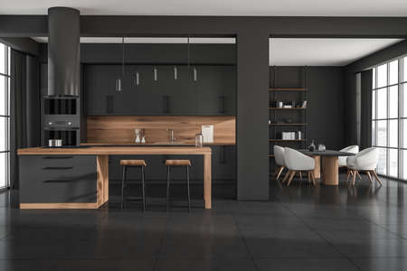 Dark kitchen interior with island cabinet and bar chairs, dining area near panoramic window with...