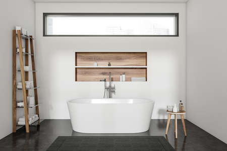 Bright bathroom interior with bathtub, shelf with towels, stool with shampoo, carpet, white walls, window, concrete floor. Concept of hygienic and spa procedures for health. 3d renderingの写真素材