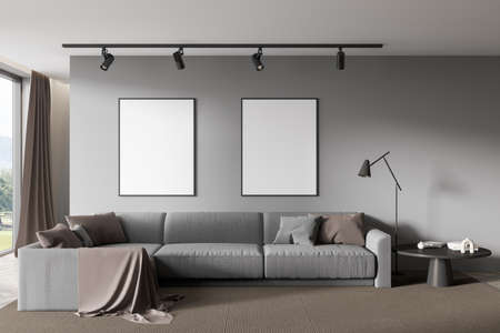 Gray relax room interior with sofa and coffee table with decoration, carpet on hardwood floor. Window with country side view, two mock up posters on wall, 3D renderingの写真素材